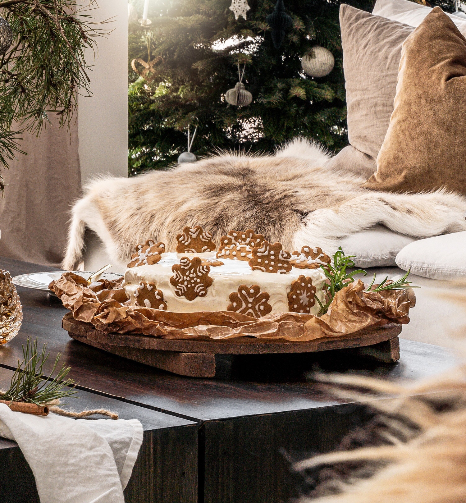 Jultårta med pepparkakor på ett bord med en julgran i bakgrunden